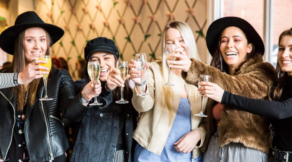 Group of friends raising glasses in a celebratory toast, sharing laughter and good cheer in a stylish, modern setting.